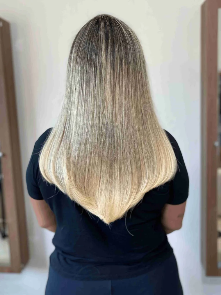 Cabelo loiro liso abaixo dos ombros, mais cheio nas pontas, vista de costas, depois da aplicação